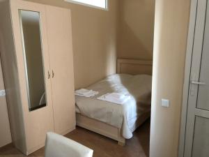 a small bedroom with a bed and a mirror at Hotel Nikea in Kutaisi