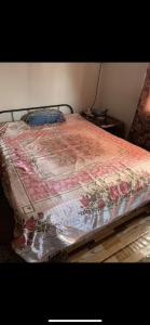 a bed with a flowered quilt on top of it at NR appartments in Curepipe