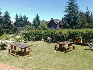 due tavoli da picnic sull'erba in un giardino di Aparts chalet Alquimia a Lago Puelo