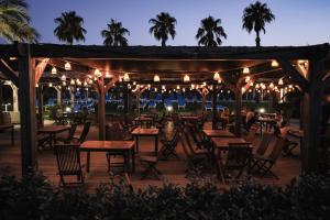 a patio with tables and chairs at night at Belambra Clubs Borgo - Pineto in Borgo