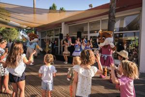 a group of children standing on a deck with mascots at Belambra Clubs Borgo - Pineto in Borgo