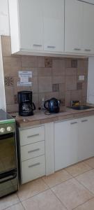a kitchen with white cabinets and a sink and a microwave at el descanso in San Antonio de Areco