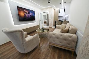 - un salon avec deux chaises et un canapé dans l'établissement Apartman 52, à Doboj