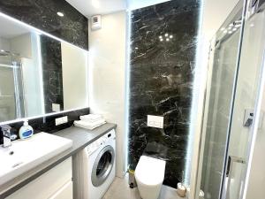 a bathroom with a washer and dryer next to a shower at Apartament Superior Blue Przy Plaży in Kołobrzeg