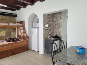 een keuken en een slaapkamer met een bed en een tafel bij Castelinho Solemar - Hot Spa - Studios e Suítes Premiums para Locação - Auto check-in - Monitoramento remoto in Praia Grande