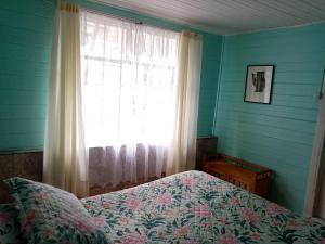 a bedroom with a bed in front of a window at La Casa del Viento in Talcahuano