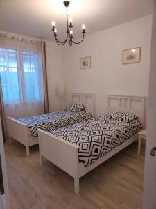 a bedroom with two beds and a chandelier at Family Residence in Baia Mare