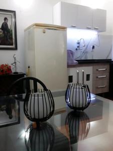 a kitchen with a glass table and two chairs at Chalé do Vale à 10 min de carro de Itacoatiara in Niterói