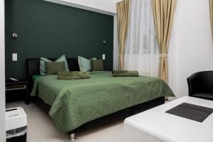 a bedroom with a green bed and a chair at Vladys Vienna Apartments in Vienna