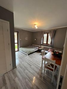 um quarto com uma cama, uma mesa e cadeiras em Beskidzka 25a em Szczyrk