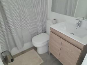 une salle de bain blanche avec toilettes et lavabo dans l'établissement Maravilloso Depto 2D2B en Condominio LagunaMar con Vista Hermosa a la Laguna Estacionamiento y Piscina, à Las Cruces