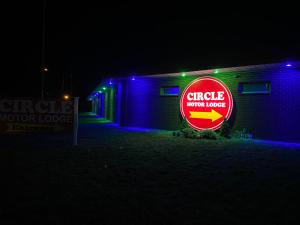 un cartello circolare per camper di fronte a un edificio di notte di Circle Motor Lodge a South Amboy