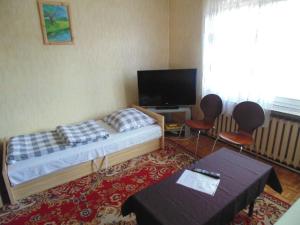 a bedroom with a bed and two chairs and a television at Villa Turysta in Białystok