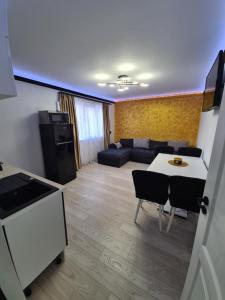 ein Wohnzimmer mit einem Sofa, einem Tisch und Stühlen in der Unterkunft Diamonds House 2 in Lupeni
