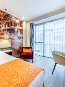 a hotel room with a bed and a chair and a window at Hotel Indigo Madrid - Gran Vía by IHG in Madrid