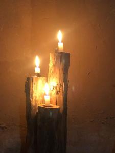 two candles sitting on top of wooden logs at Sahara Authentic Berber Camp in Mhamid