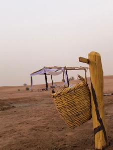 a basket on a pole in the desert at Sahara Authentic Berber Camp in Mhamid