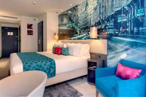 a hotel room with a bed and a chair at Hotel Indigo Madrid - Gran Vía by IHG in Madrid