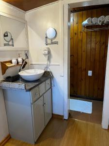 a bathroom with a sink and a counter with a mirror at Apartamento Foss in Gramado