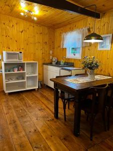 a kitchen with a wooden floor and a table with chairs at Apartamento Foss in Gramado
