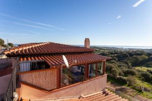 a house with a roof with a view of the countryside at La finestra sul mare in Budoni