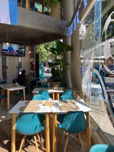 um restaurante com mesas de madeira e cadeiras azuis em Moderno alojamiento con desayuno de bienvenida em San Miguel de Tucumán
