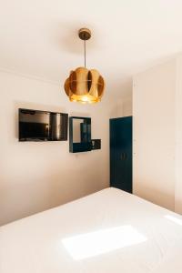 a bedroom with a bed and a light fixture at TSA La Mare in Barcelona