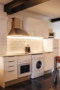 a kitchen with a stove and a washing machine at TSA La Mare in Barcelona