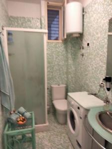 a bathroom with a toilet and a sink and a washing machine at SeaSide in Giardini Naxos