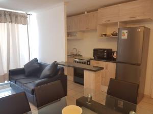 a living room with a couch and a kitchen at Depto con internet y tv cable in Ovalle