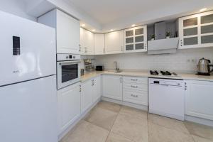 una cocina blanca con electrodomésticos blancos y armarios blancos en Amazing Duplex House with Sea View in Bodrum, en Gümüşlük