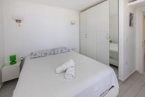 a white bedroom with a bed with two towels on it at Amazing Duplex House with Sea View in Bodrum in Gumusluk