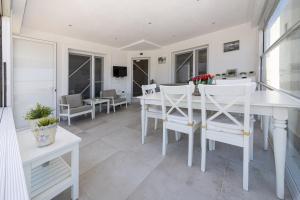 a dining room with a white table and chairs at Amazing Duplex House with Sea View in Bodrum in Gumusluk