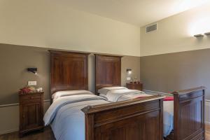 a bedroom with two beds with wooden headboards at VILLA ANNA ELISA 8, Emma Villas in Bevagna +51 photos