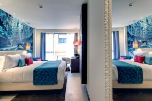 a hotel room with two beds and a mirror at Hotel Indigo Madrid - Gran Vía by IHG in Madrid