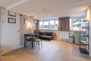 een woonkamer met een tafel en stoelen en een bank bij Blankebil Studios & Apartments in Zandvoort
