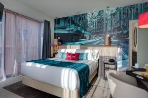 a hotel room with a large bed and a chair at Hotel Indigo Madrid - Gran Vía by IHG in Madrid