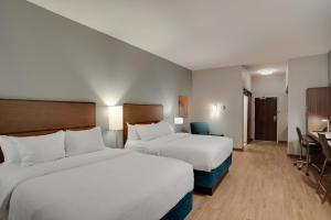 Habitación de hotel con 2 camas y escritorio en MainStay Suites Carlisle - Harrisburg, en Carlisle