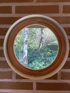 une fenêtre ronde dans un mur de briques dans l'établissement La Iguana Perdida, à Santa Cruz La Laguna