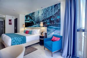 a hotel room with a bed and a blue chair at Hotel Indigo Madrid - Gran Vía by IHG in Madrid