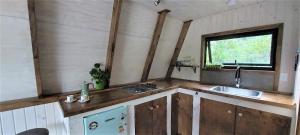 uma cozinha com armários de madeira, um lavatório e uma janela em Molco Alpina em Molco