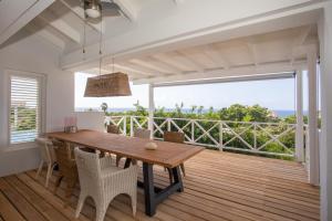 comedor con mesa de madera y balcón en Piscadera Bay Resort 102 en Willemstad