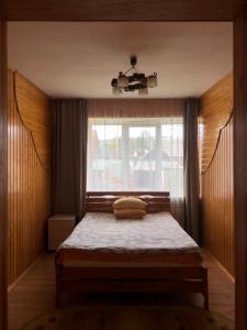 Dormitorio pequeño con cama y ventana en Nadiira, en Slavske