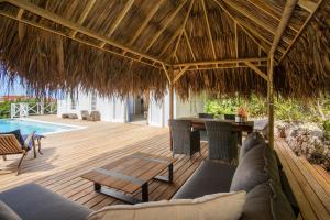 un patio al aire libre con una mesa y una terraza de madera en Piscadera Bay Resort 102 en Willemstad