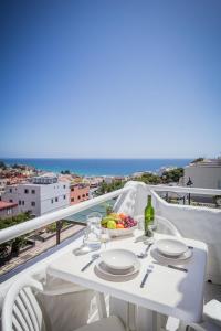 un tavolo bianco con un cesto di frutta sul balcone di Apartamentos NataLis a Morro del Jable