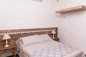1 dormitorio con 1 cama y 2 mesitas de noche con lámparas en Solar de Amelia, en Tiradentes