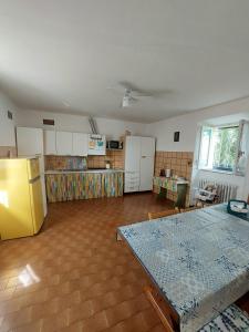 eine Küche mit einem gelben Kühlschrank und einem Tisch in der Unterkunft Da Simona- casa 4 posti letto + 4 aggiuntivi in Arona