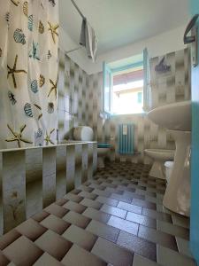 baño con lavabo y aseo y ventana en Da Simona- casa 4 posti letto + 4 aggiuntivi, en Arona