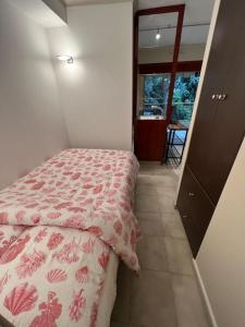 1 dormitorio con 1 cama con edredón rojo y blanco en Superbe studio avec terrasse au cap d’antibes, en Antibes