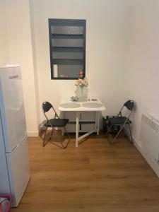 ein weißer Tisch mit zwei Stühlen und ein Tisch mit Blumen darauf in der Unterkunft ZUM GUTEN HIRTEN in Traben-Trarbach